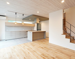 アイランドキッチンが家族のコミュニケーションの場となる住まい。天然木で部屋全体が温もりの空間に。